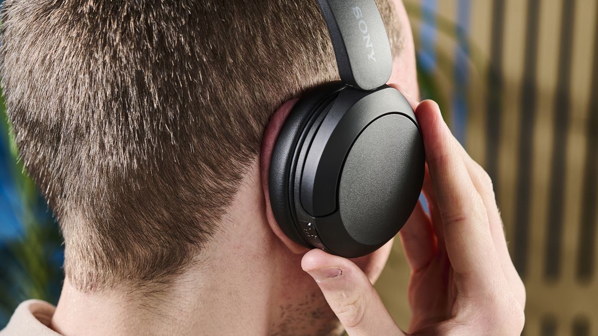 A person wearing modern wireless Bluetooth headphones for a call.